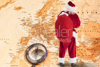 Composite image of santa is holding his bag in one hand