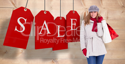 Composite image of happy blonde in winter clothes with bags