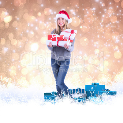 Composite image of festive blonde holding pile of gifts