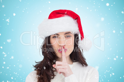 Composite image of festive brunette keeping a secret