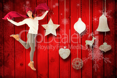 Composite image of happy brunette jumping and holding his scarf