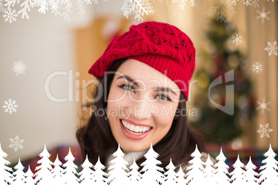 Composite image of portrait of a smiling brunette in hat at chri