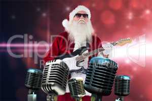 Composite image of santa claus plays guitar with sunglasses