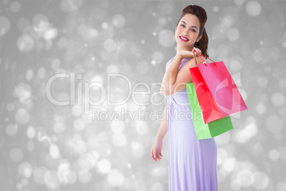 Composite image of elegant brunette posing with shopping bags