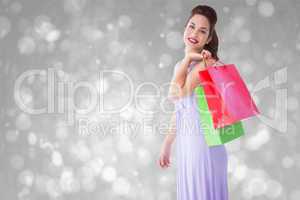 Composite image of elegant brunette posing with shopping bags