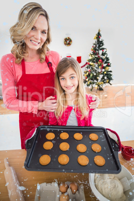 Composite image of festive mother and daughter making christmas cookies