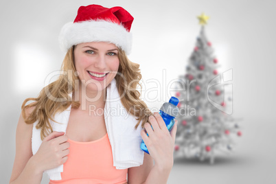 Composite image of festive fit blonde holding bottle of water
