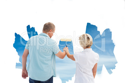 Composite image of happy older couple painting a sky