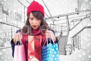 Composite image of shocked brunette opening gift bag