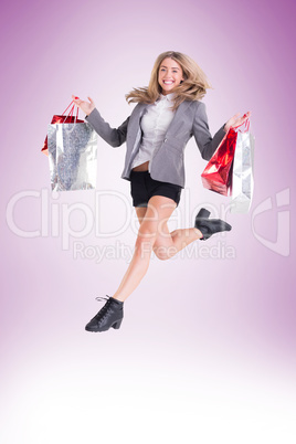 Festive blonde jumping with shopping bags