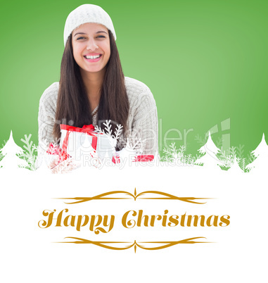 Composite image of festive brunette holding gifts