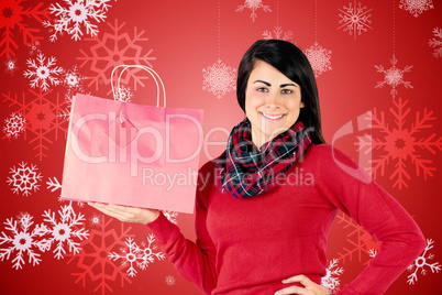 Smiling brunette showing red gift bag