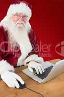 Composite image of santa surfs on the internet