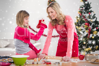 Composite image of festive mother and daughter making christmas