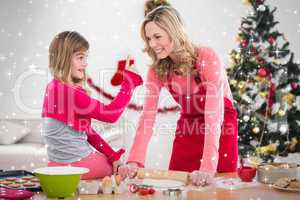 Composite image of festive mother and daughter making christmas