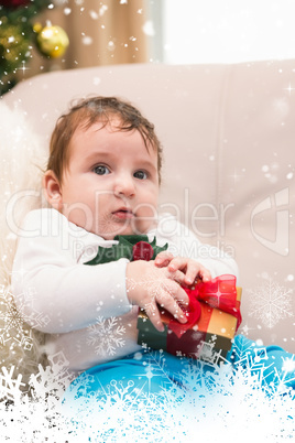 Composite image of cute baby boy on the couch at christmas