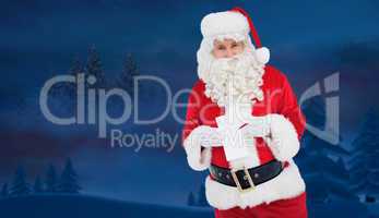 Composite image of happy santa holding paper and pen