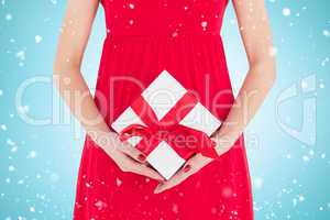 Composite image of woman in red dress holding gift