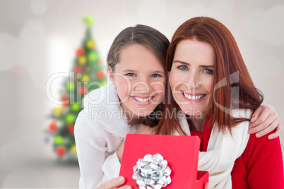 Composite image of mother and daughter with gift