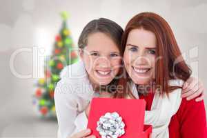 Composite image of mother and daughter with gift