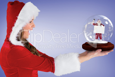 Composite image of sexy santa girl holding snow globe