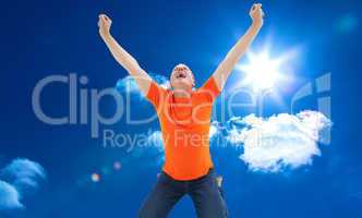 Composite image of mature man in orange tshirt cheering while kn