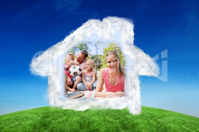 Composite image of smiling woman reading at a picnic with her fa