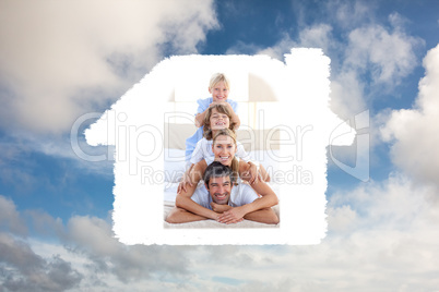 Composite image of happy family having fun on a bed