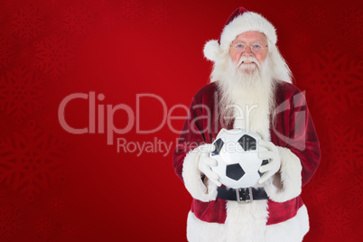 Composite image of santa holds a classic football