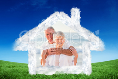 Composite image of man hugging his wife on the beach