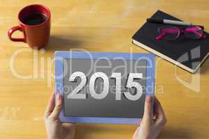 Composite image of businesswoman using tablet at desk