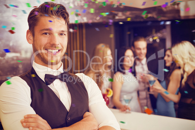 Composite image of handsome barman smiling at camera