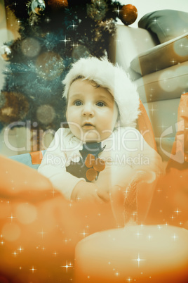 Composite image of cute baby boy in large christmas present