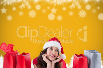 Composite image of festive brunette lying with shopping bags