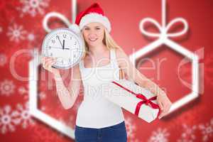 Composite image of festive blonde holding a clock and gift