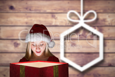 Composite image of festive blonde holding a gift