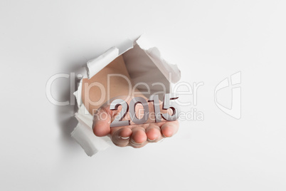 Composite image of hand presenting through paper