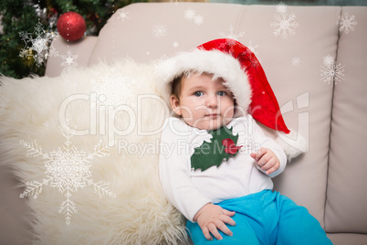 Composite image of cute baby boy on couch at christmas