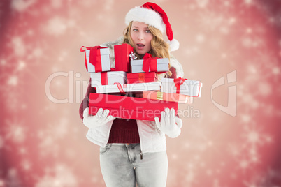Composite image of blonde woman in trouble holding pile of gifts