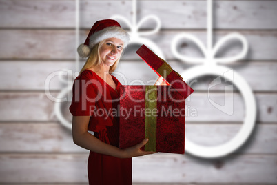 Composite image of festive blonde opening a gift