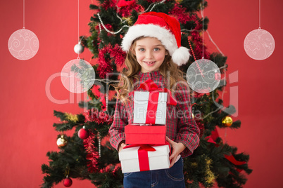 Composite image of festive little girl holding gifts