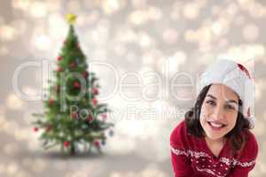 Composite image of happy brunette sitting and wrapping christmas