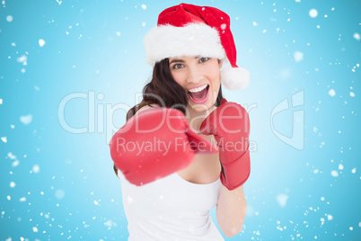 Composite image of festive brunette in boxing gloves punching