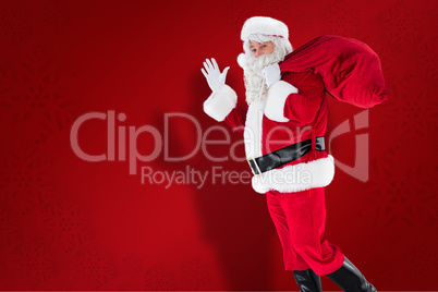 Composite image of santa holding a sack and waving Composite image of santa holding a sack and waving
