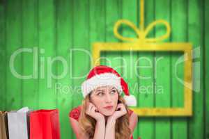 Composite image of thoughtful woman lying between shopping bags