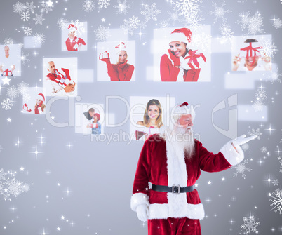 Composite image of santa shows something to camera