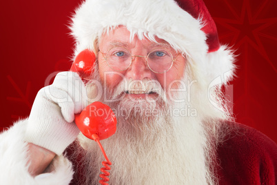 Composite image of santa on his red phone