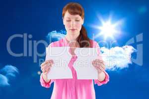 Composite image of woman holding torn sheet of paper