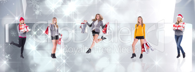 Composite image of festive blonde holding pile of gifts