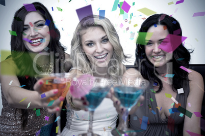 Composite image of pretty friends drinking cocktails together